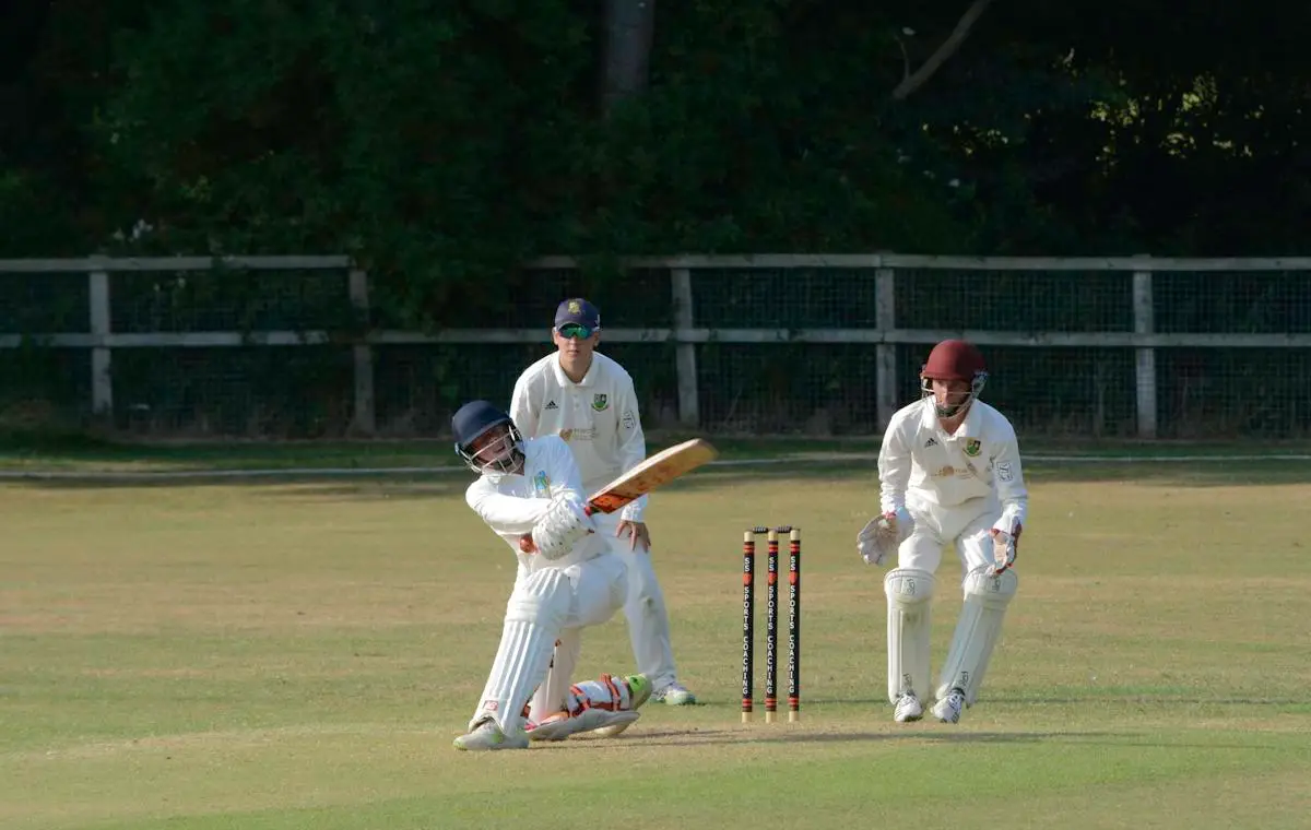 Batter playing a sweep shot with wicketkeeper and slip fielder watching